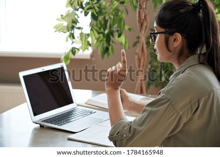 Over shoulder view of professional indian female teacher, remote tutor gives online class by webcam video conference call app teach by videoconference hangouts virtual meeting working at home office. Royalty-Free Stock Photo #1784165948