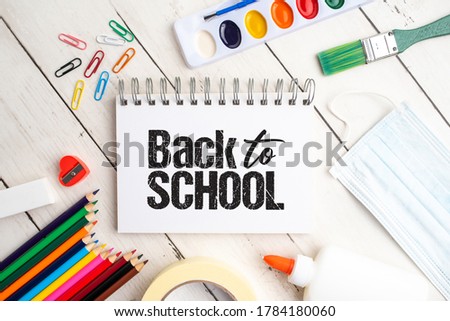Back to school supplies for COVID 19 with mask on white wood background 