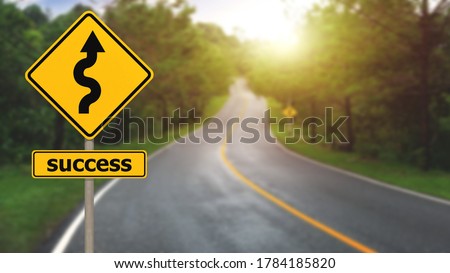Winding road sign with success sign to the mountain in the middle of the forest with many trees. Concept for success in the future goal and passing time