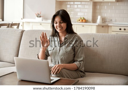 Smiling young indian woman video calling using laptop webcam conference work at home office. Happy lady sit on sofa talk by virtual videoconference meeting dating online using computer app videocall. Royalty-Free Stock Photo #1784190098