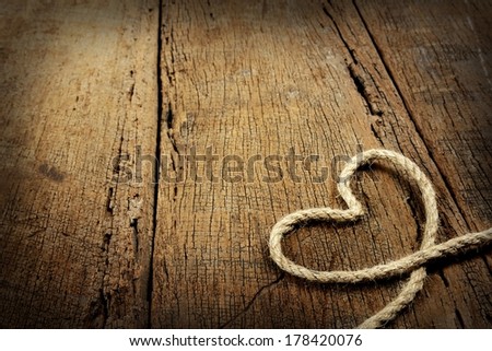 jute rope in heart shaped isolated on wooden background