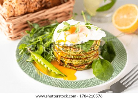 green pancakes with spinach and poached egg. Tasty healthy european breakfast