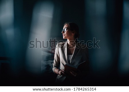 Portrait businesswoman with glasses in the office with a book in hand