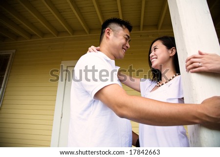 A shot of a happy asian couple standing in front of the house