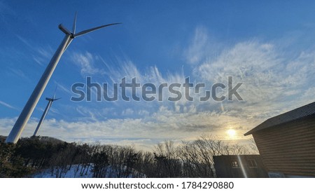 It's a picture of wind power in the background of the sky.
