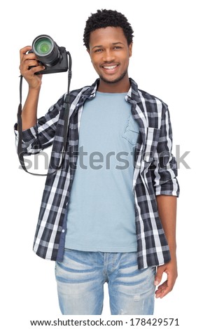 Portrait of a happy male photographer standing over white background