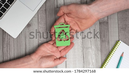 Hands holding a recycling bin; Concept of recycling