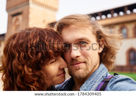 Beautiful positive traveling couple making selfie on european castle background, sunny autumn colors, romantic mood. Travel, happiness and lifestyle concepts.