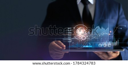 Businessman using tablet analyzing sales data and economic growth graph chart. Business strategy. Abstract icon. Stock market, Banking and Digital marketing. 