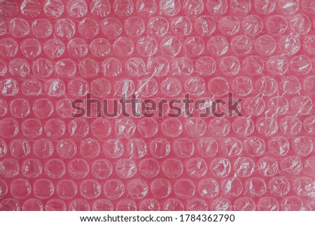 Packaging with air bubbles on a pink background. Bubble wrap texture, packaging, air bubble film. Top view. Copy, empty space for text