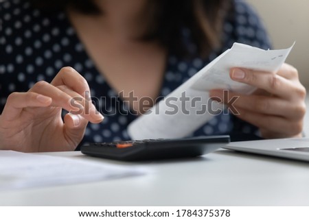Crop close up of young woman calculating family household expenses expenditures using calculator machine, female count utility bills manage finances at home, do savings for future, economic concept Royalty-Free Stock Photo #1784375378