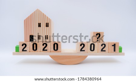 Scale comparing 2020 and 2021 housing market trends, question on real estate economics future plan and property value analysis. Business concept of forecasting financial effect from coronavirus crisis Royalty-Free Stock Photo #1784380964