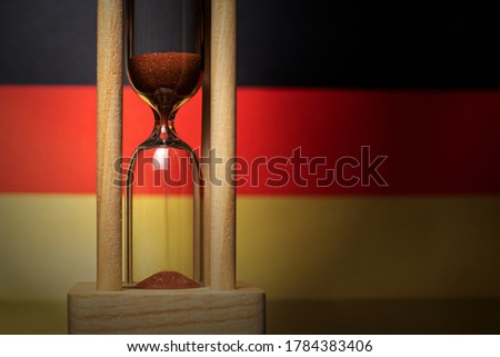 Hourglass and Germany flag, soft focus, copy space