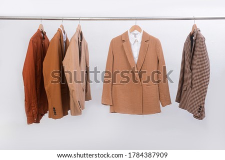 Woman three brown and striped ,white fashion suit with brown,white  long sleeve shirt on hanger
