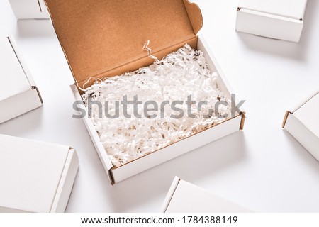 White paper filler in cardboard box, set of white carton boxes Royalty-Free Stock Photo #1784388149