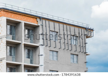 Gray facade with a windows and balcony of a new under construction modern city house on a construction site