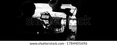 Behind the scenes of video production in studio which filming a online movie with professional set up such as high definition vdo camera, lens, monitor or tripod and crane beside crew team. Royalty-Free Stock Photo #1784405696