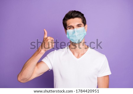 Close-up portrait of attractive healthy guy wearing safety gauze mask showing thumbup influenza preventive measures isolated bright vivid shine vibrant lilac violet purple color background Royalty-Free Stock Photo #1784420951