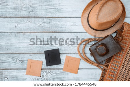 Lay flat white wooden background, vintage summer accessories, vintage film camera, save memories of summer. pictures in frames
