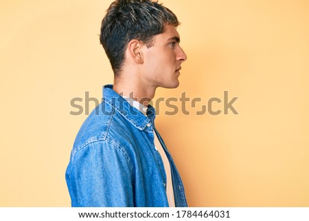 Young handsome man wearing casual clothes looking to side, relax profile pose with natural face with confident smile. 
