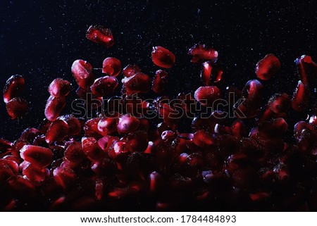 Water drops on ripe sweet pomegranate seeds. Fresh pomegranate background with copy space for your text. Vegan and vegetarian concept.