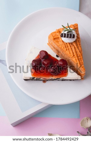 Top view of the slice of layer cake ; Red juicy berry cheesecake and Creamy tea layer cake