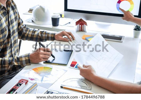 Team of young Interior graphic designer working sketching on graphic tablet and color swatch, discussing of house project at modern office, creative work place inspiration and imagine.