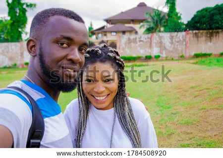 two cute african couples feeling excited as they are taking selfie with their smartphone