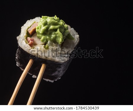 Sushi roll close-up on a black background. Japanese traditional food concept.