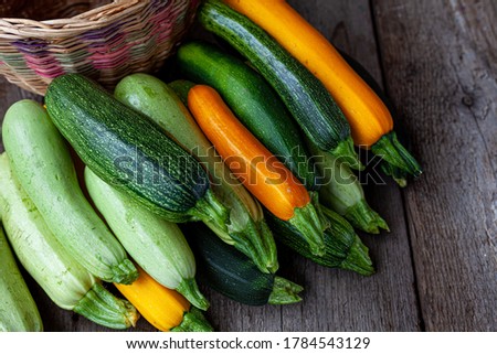 A set of multi-colored zucchini yellow, green, white, orange on the table close-up. Food background. Fresh harvested courgette, cropped summer squash. Picked green courgettes. Still life in kitchen. Royalty-Free Stock Photo #1784543129