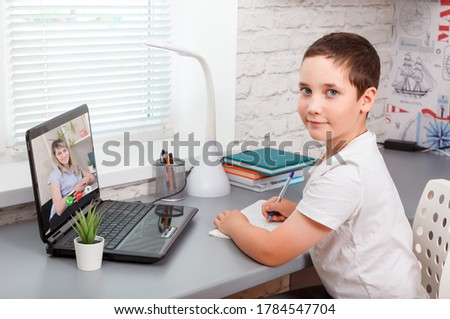 Child attending to online school class. Online child education. Learning from home, homeschooling, home school kid concept. Covid-19, coronavirus, quarantine and social distancing concept. New normal Royalty-Free Stock Photo #1784547704