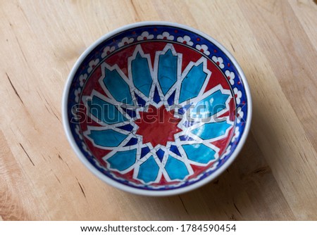 Macro shot off abstract decorative home objects in colorful ceramic bowls on wooden floor buying now.