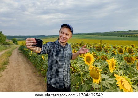 farmer in the sunflower field, recording content for the lifestyle blog vlog, modern farmer using social media for marketing