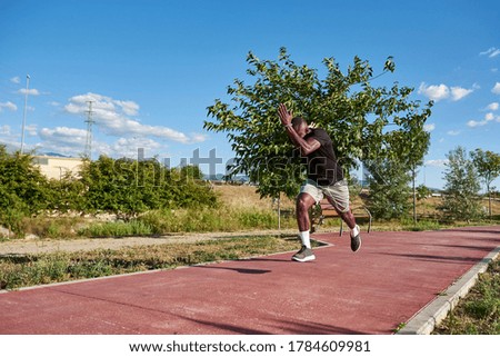 African athlete running on a sunny summer day. Space for text in the image.