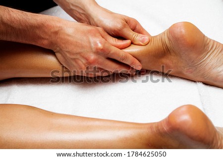 Female feet close up. Photo of massage of legs and feet. Male hands of a masseur.