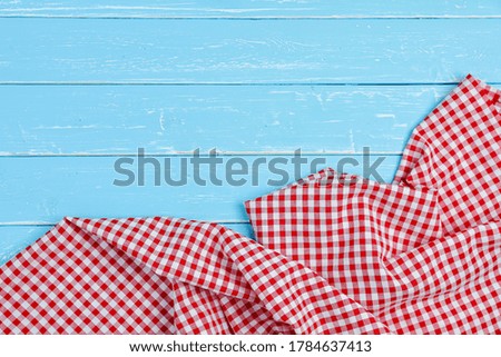 Tablecloth red and white checkerboard pattern on old blue wooden table with copy space for a background.