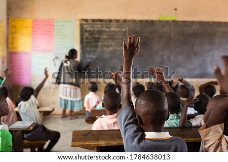 Happy students at a school in Uganda, Africa.  Students raising their hands. Royalty-Free Stock Photo #1784638013