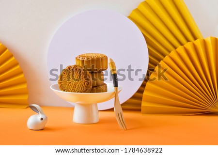 Abstract still life Mid autumn festival snack and drink moon cake on yellow  and orange background. 