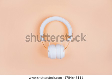 Flatlay with stylish white headphones isolated on turquoise background.