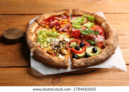 Slices of different delicious pizzas on wooden table