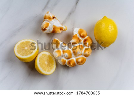 Close-up of fresh homemade Lemon pie with meringue and lemon citrus fruit. Bakery concept.