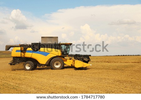 Modern combine harvester in field on sunny day. Agricultural machinery
