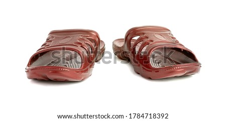 pair of cheap durable orange rubber slippers isolated on white background.