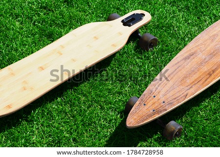 Wooden longboards on green grass top view