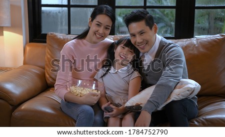 Family concept. An Asian family is watching television inside the house.