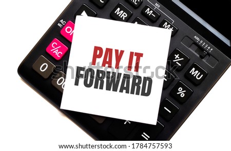 calculator with text PAY IT FORWARD with white paper