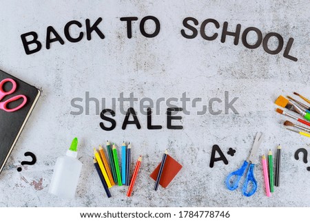 Text sale on white background with school supplies. Top view.