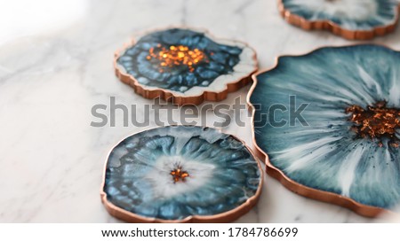 Cup holder, epoxy resin tray, marine-style stone cut. Blue stains of paint, gold trim. Subject for table setting. Gloss, reflection. Royalty-Free Stock Photo #1784786699