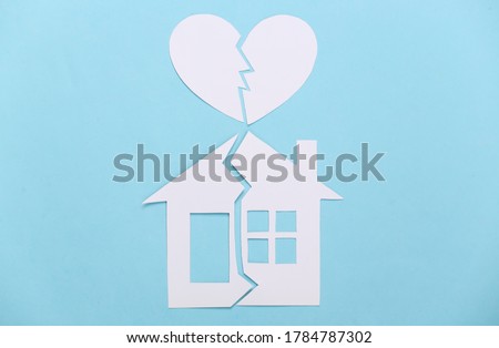 Divorce, property division concept. Split paper house and broken heart on blue background