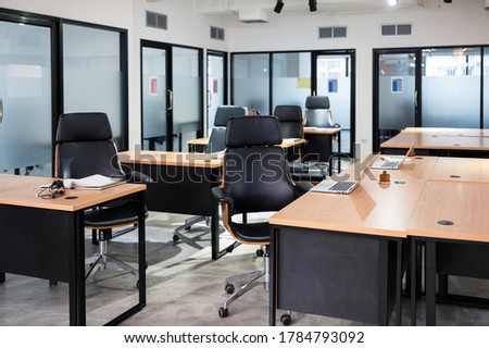 Empty modern office with desk, chair, laptop temporarily closed from government measures protective during pandemic of Coronavirus, Covid-19 Royalty-Free Stock Photo #1784793092